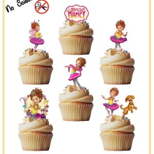 Op de afbeelding: Zes cupcake-toppers met Fancy Nancy, een cartoonfiguur met rood haar, die een roze jurk en een kroon draagt. De toppers zijn voorgeknipt en klaar voor gebruik. Geen schaar nodig. "Fancy Nancy" staat op de topper.