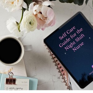 May include: An overhead shot features a tablet displaying "Self Care Guide for the Night Shift Nurse" in pink text. A cup of coffee, a notebook, and flowers are arranged on a white surface, creating a calming aesthetic.