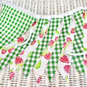 May include: A green and white gingham fabric banner with a raspberry print. The banner is made of 10 flags and has a white ribbon for hanging.