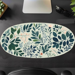 May include: Oval-shaped green and white floral print with a light green background. The print features various shades of green leaves and small pink flowers.