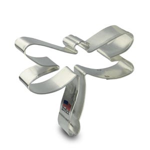May include: Silver metal cookie cutter shaped like a dragonfly. The cutter has a detailed design and is made in the USA.