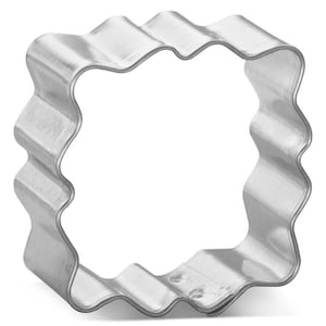 May include: A silver metal cookie cutter shaped like a square with wavy edges.