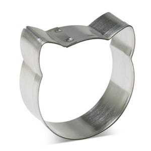 May include: A silver metal cookie cutter shaped like a bear's head.