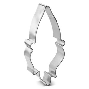 May include: A silver metal cookie cutter shaped like a stylised leaf with a pointed tip and a scalloped edge.