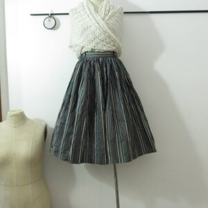 May include: A black and white striped skirt with a teal stripe. The skirt is full and has a high waist.