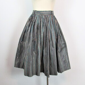 May include: A black and white striped skirt with a hint of blue and pink. The skirt is full and has a gathered waist.