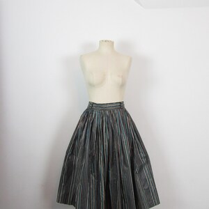 May include: A black and white striped skirt with a teal stripe. The skirt is full and has a gathered waist.