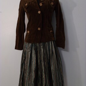May include: A brown corduroy jacket with wooden buttons and a black and white striped skirt.