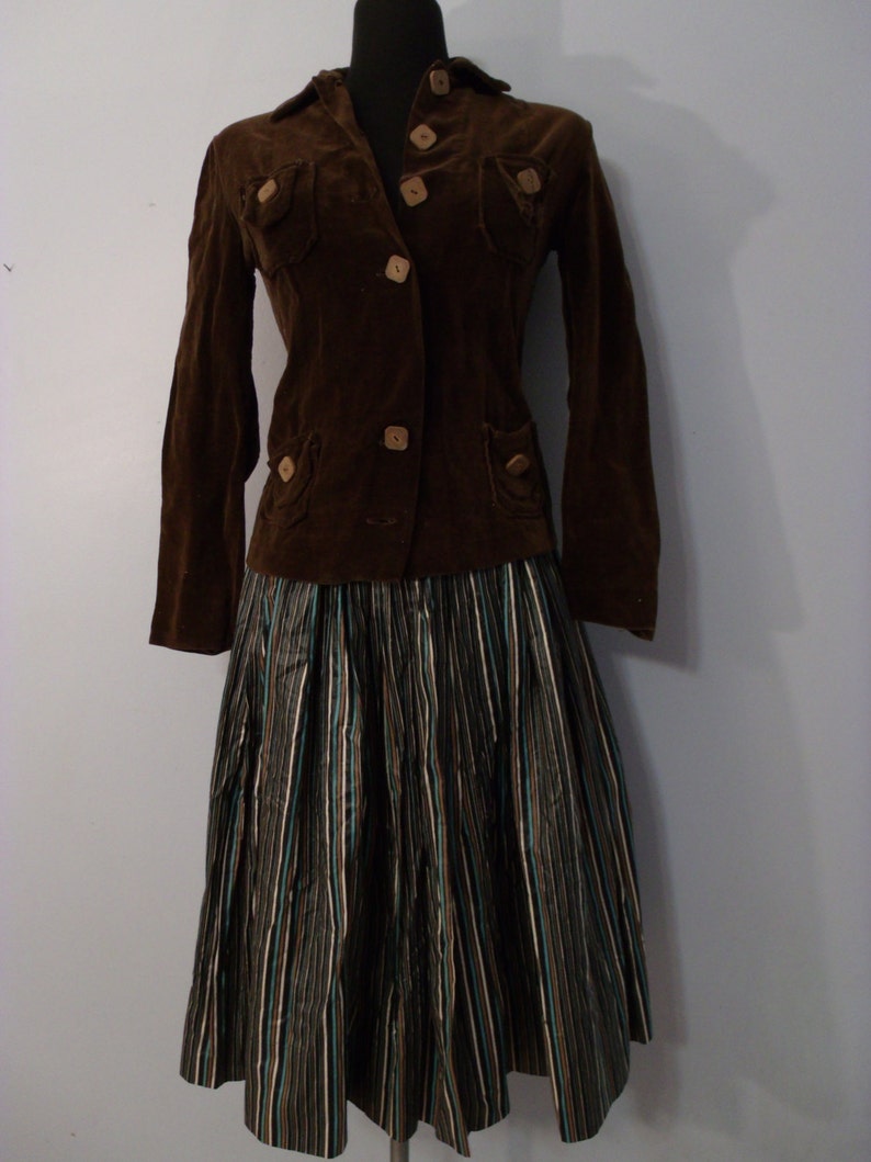 May include: A brown corduroy jacket with wooden buttons and a black and white striped skirt.