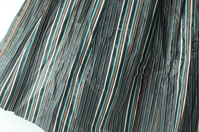 May include: A close-up of a fabric with vertical stripes in black, brown, white, and teal.