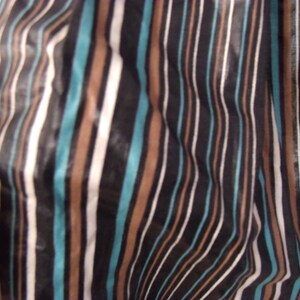 May include: Close-up of a fabric with a striped pattern in black, white, brown, and teal.