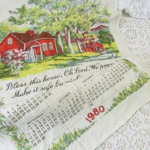 May include: A vintage linen tea towel with a red house illustration and a calendar for September, October, and November of 1980. The text reads "Bless this house, Oh Lord, We pray, Make it safe by night."