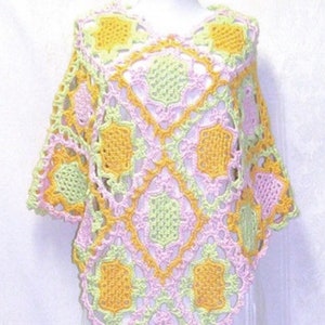May include: A crocheted poncho with a geometric pattern in shades of pink, yellow, and green.