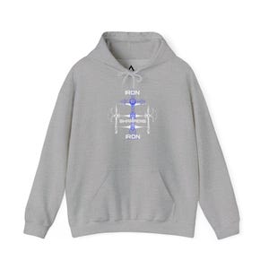Op de afbeelding: Een grijze hoodie met een voorzak en trekkoord. De voorkant heeft een blauw-witte afbeelding van een kruis met bijlen en de tekst "IRON SHARPENS IRON". Een casual, comfortabele top.
