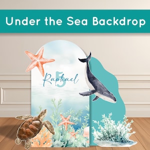 May include: A decorative backdrop with an "Under the Sea" theme. The backdrop features a whale, starfish, and a sea turtle. The name "Raphael" and the number "5" are also visible. The backdrop is designed with an underwater scene.