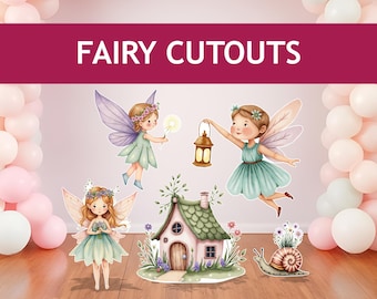 May include: A set of five fairy cutouts for a party or event decoration. The cutouts include three fairies with wings, a small house, and a snail. The fairies are wearing green dresses and have brown hair with flowers. The house is green and pink with a brown door. The snail is brown with a green shell.