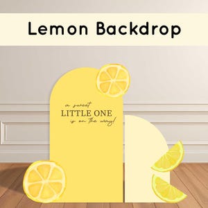 May include: A yellow backdrop with a lemon theme. The backdrop has a rounded top and features lemon slices and the text "Lemon Backdrop" and "a sweet LITTLE ONE is on the way!"