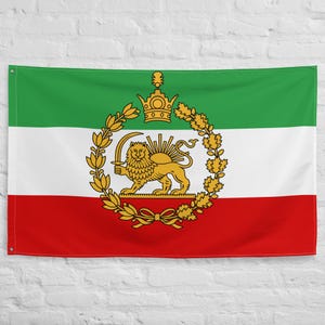 Op de afbeelding: Een rechthoekige vlag met horizontale strepen in groen, wit en rood. De middelste witte streep toont een gouden embleem van een leeuw met een zwaard, met een opkomende zon erachter, omringd door een krans en een kroon.