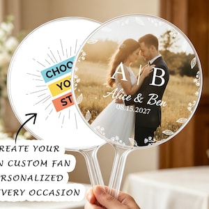May include: Two round handheld fans with clear plastic handles. One fan features a photograph of a couple with the text A | B, Alice & Ben, and 08.15.2027. The other fan displays the text CHOOSE YOUR STORY with a sunburst graphic design.