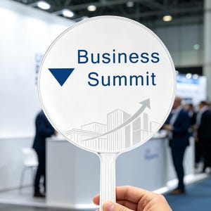May include: A round white handheld sign with a handle featuring the dark blue text Business Summit, a dark blue downward-pointing triangle, and a light gray graphic illustration of city buildings with an upward-trending arrow overlay.