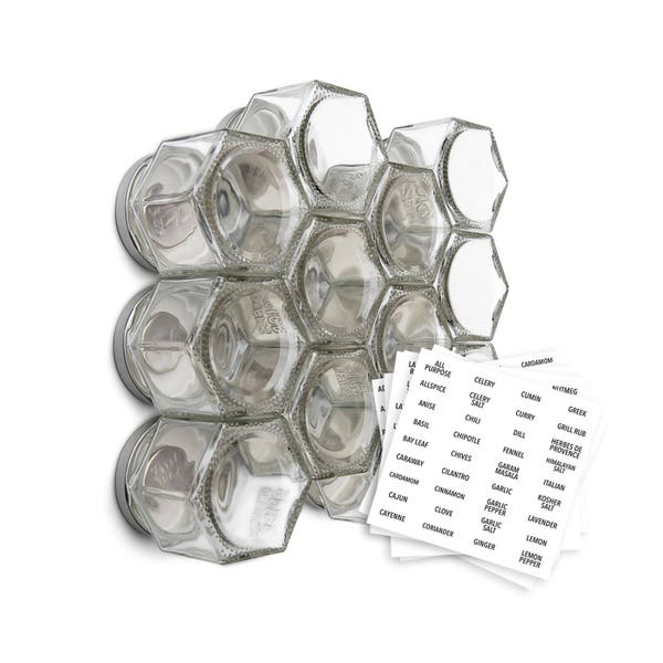 Könnte beinhalten: Ein magnetischer Gewürzregal mit 12 durchsichtigen Glasbehältern, jeweils mit einem silbernen Deckel. Das Regal ist wabenförmig und an einer weißen Wand befestigt. Das Regal wird mit Etiketten für verschiedene Gewürze geliefert, darunter Piment, Anis, Basilikum, Lorbeerblatt, Selleriesalz, Chili, Schnittlauch, Zimt, Nelke, Koriander, Kreuzkümmel, Curry, Dill, Fenchel, Knoblauch, Knoblauchpfeffer, Ingwer, Griechisch, Kräuter der Provence, Italienisch, koscheres Salz, Lavendel, Zitrone, schwarzer Pfeffer und malaysisches Salz.