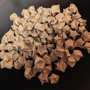 May include: A white ceramic mug with a black handle and the text "But First, Coffee" in a black, bold font. The mug is sitting on a wooden surface. The mug is approximately 4 inches tall.