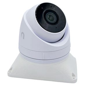 May include: A white security camera with a black lens and a white base. The camera is mounted on a wall.