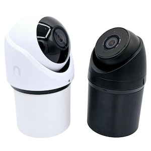 May include: Two security cameras, one white and one black, are displayed against a white background. The white camera has a rounded top with a black lens and a cylindrical base. The black camera has a similar design.