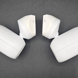 Puede incluir: Dos luces de seguridad blancas con sensor de movimiento y diseño redondeado. Las luces se enfrentan y están conectadas por una pequeña pieza de plástico blanca.