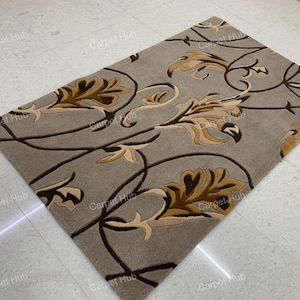 May include: Rectangular rug with a grey backdrop and a floral design in brown and beige tones. The rug showcases a repeating pattern of stylized leaves and vines, offering a classic and elegant aesthetic. Ideal for living rooms and bedrooms, this rug measures approximately 170 cm x 240 cm.