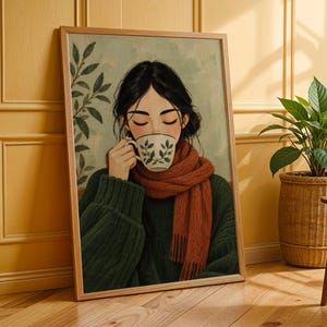 Può includere: Una stampa artistica incorniciata raffigurante una persona dai capelli scuri, che indossa un maglione verde scuro e una sciarpa spessa e testurizzata color ruggine, mentre tiene una tazza bianca con motivo a foglie verdi su sfondo verde chiaro.