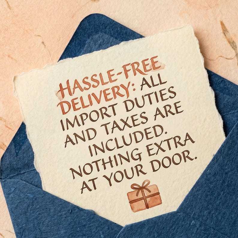 May include: A cream-colored card with the text "HASSLE-FREE DELIVERY: ALL IMPORT DUTIES AND TAXES ARE INCLUDED. NOTHING EXTRA AT YOUR DOOR." is inside a dark blue envelope. A small brown gift box illustration is at the bottom.
