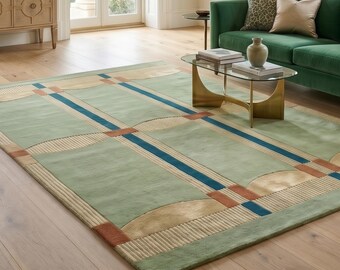 May include: A large, rectangular area rug with a geometric design. The rug features a light green background with a grid pattern of blue, tan, and rust-colored accents. The rug is placed on a hardwood floor in a living room setting.
