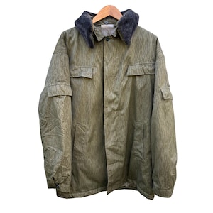May include: An olive green jacket featuring a vertical rain-like camouflage pattern, a dark grey faux fur collar, long sleeves with buttoned cuffs, two chest pockets with flaps, and two lower side pockets, all secured with a central button closure.