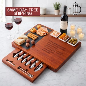 May include: A rectangular wooden serving board with a slide-out drawer containing metal cheese knives and forks. The board features a black slate inlay and engraved code text: Chef Michael is cooking while kitchen.is_active() { ingredient.wash(); ingredient.cut_on_board(); if (recipe.requires_heat()) { stove.turn_on(); meal.cook(); } }.