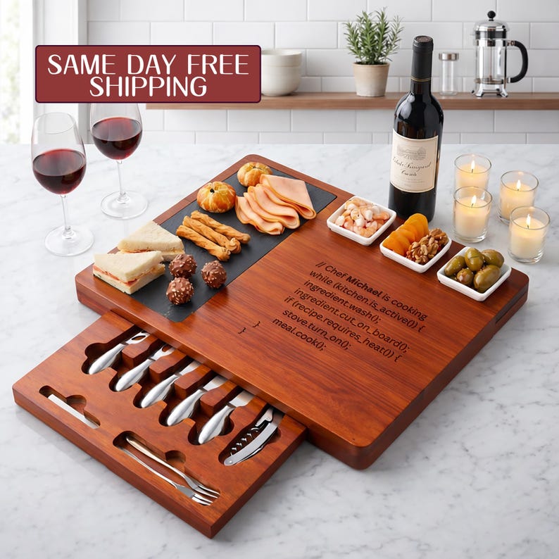 A custom wooden charcuterie board with a pull-out utensil drawer, arranged with snacks and a bottle of wine. The board is laser-engraved with a funny computer programming code block detailing a cooking recipe algorithm for