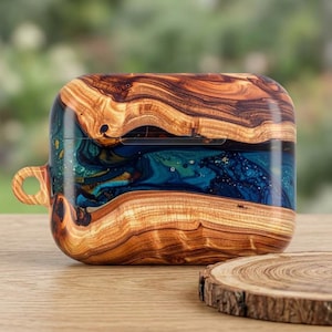 May include: A protective case for wireless earbuds featuring a horizontal band of deep blue and teal resin with gold flecks, sandwiched between two pieces of natural wood with a prominent grain pattern and a small circular loop on the left side.