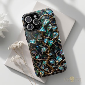 May include: A black smartphone case with a decorative design of gold-colored vines and iridescent leaves. The case has a glossy finish and features a multi-lens camera system. The design includes the text "EVERY STYLE CREATIONS".