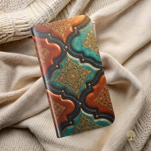 May include: A rectangular phone case featuring a repeating quatrefoil pattern in shades of burnt orange, teal, and black. The design includes intricate gold filigree scrollwork and small gold studs at the intersections of the dark borders.