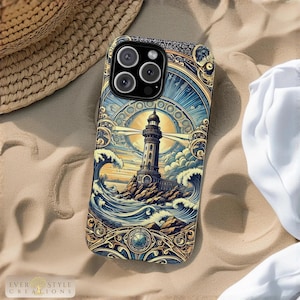 May include: A phone case featuring a lighthouse design. The case has a detailed illustration of a lighthouse on a rocky island, with waves and a sunburst background. The case is on a sandy surface, with a straw hat and white fabric in the background.
