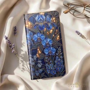 May include: A rectangular wallet featuring a dark blue background with a detailed floral pattern of blue irises and orchids, accented by gold outlines. The design includes small light blue flowers at the bottom and a gold border around the edges.