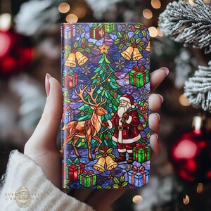 May include: A rectangular phone case featuring a vibrant stained glass design of Santa Claus, a reindeer, a Christmas tree, and wrapped gifts. The artwork includes golden bells, snowflakes, and a rich color palette of red, green, blue, and purple.