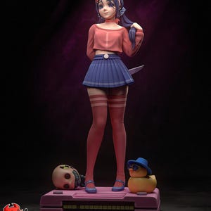 May include: A stylized anime-style figurine of a character with dark blue hair, wearing a peach-colored long-sleeve crop top and a pleated blue skirt. The figure stands on a pink base with a skull and a yellow duck wearing a blue hat.