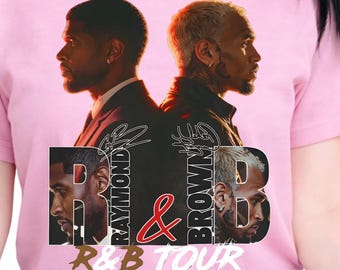 Peut inclure: Un t-shirt rose clair à manches courtes avec une impression graphique représentant deux hommes dos à dos. Le texte RAYMOND & BROWN R&B TOUR est imprimé en lettres noires et blanches au centre, avec des portraits de profil des hommes.