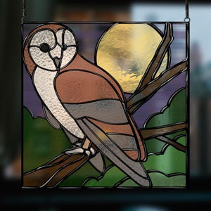 May include: Stained glass window panel featuring a brown and white barn owl perched on a branch with a yellow moon in the background. The owl has a detailed design with black outlines and a textured appearance.