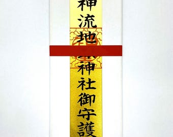May include: A rectangular white package with gold and red accents. The package has Japanese text in black ink. The gold section has Japanese text. A red band wraps around the middle of the package.
