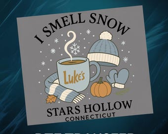 Puede incluir: Un diseño de transferencia DTF gris con una taza con la inscripción "Luke's", una bufanda azul y blanca, un gorro azul, mitones, una calabaza y el texto "I Smell Snow" y "Stars Hollow Connecticut".