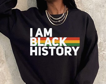 May include: Black sweatshirt with the text "I AM BLACK HISTORY" in white letters with a rainbow stripe above the word "BLACK".