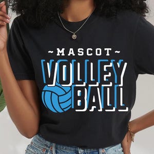Könnte beinhalten: Schwarzes T-Shirt mit weißem Text "~MASCOT~ VOLLEY BALL" und einer blauen Volleyballgrafik.