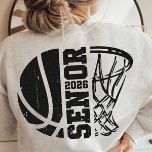 May include: A gray sweatshirt with a black basketball and basketball hoop graphic. The graphic includes the word "Senior" and the year "2026".